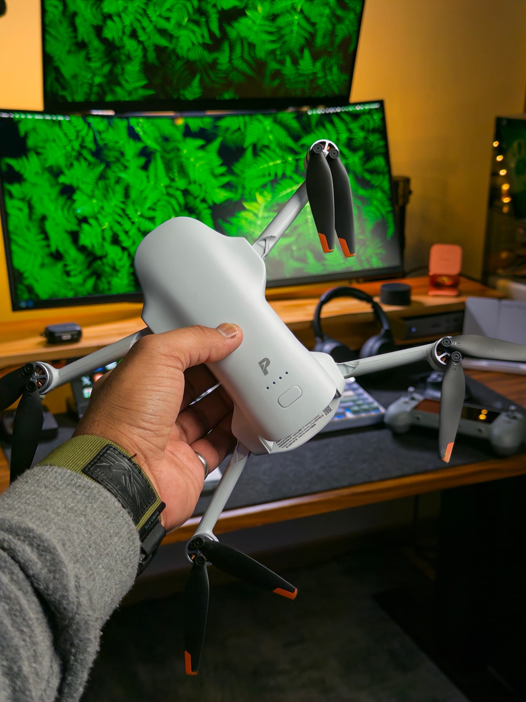 Potensic ATOM 3 drone held in front of a desk setup